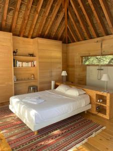 a bedroom with a bed and a wooden ceiling at Lodge dans les arbres in Villevieille