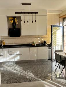 a kitchen with white cabinets and a table in it at Atlantic Foz in Buarcos