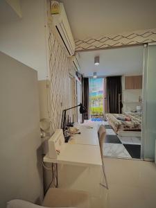 a room with a white desk and a living room at Stylish Bangkok Condo Furnished, Pool View Prime Location in Ban Nong Chaeng