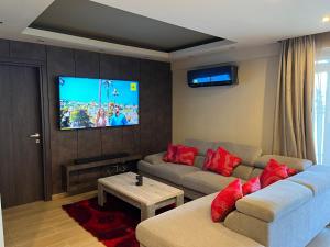 a living room with a couch and a flat screen tv at Oasis Penthouse Luxury Suite in Limassol