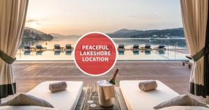 a view of a pool from a resort with a sign at Falkensteiner Schlosshotel Velden – The Leading Hotels of the World in Velden am Wörthersee +27 photos