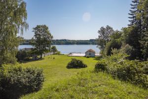a house on a field next to a lake at Villa Kolartorp in Ekolsund +185 photos
