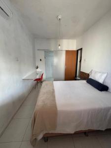 a bedroom with a large bed and a red chair at Casa do sossego in Juazeiro do Norte