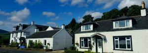 a row of white houses on the side of a street at The Bay Rooms at Glenisle Hotel in Lamlash