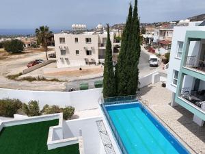 an aerial view of a building with a swimming pool at Peyia Sunset Luxury in Paphos City