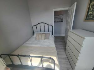 コークにあるTop Location - Newly Refurbed 2BD Sleeps 6 W Loftのベッドとドレッサーのある小さな寝室
