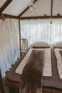 a bedroom with two beds in a tent at Camping Zanzibāra in Ķekava