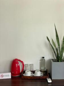 a shelf with a tea kettle and glasses and a potted plant at Ko Lake Room in Ahangama