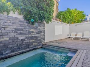 a swimming pool with two chairs on a wooden deck at Le Paradis 5 in Hermanus