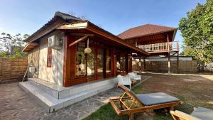 a small house with a porch and a patio at Lagoona Resort Gili Gede in Gili Gede