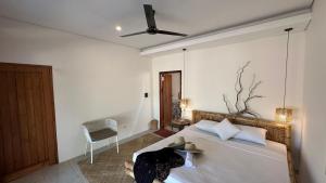 Un dormitorio con una cama y un ventilador de techo. en Lagoona Resort Gili Gede, en Gili Gede