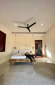 Un dormitorio con una cama con ventilador de techo. en Lagoona Resort Gili Gede, en Gili Gede 10 fotos más