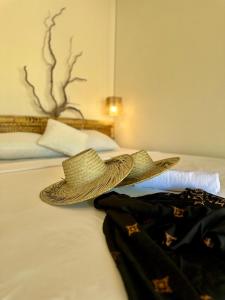 un sombrero sentado en la parte superior de una cama en Lagoona Resort Gili Gede, en Gili Gede