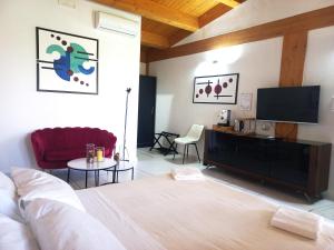 a bedroom with a bed and a flat screen tv at Limora' Tenuta Millaci in Mazzarino