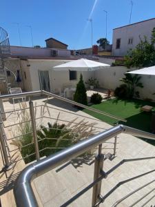 a metal railing in front of a house with an umbrella at Brezza marina in Taranto