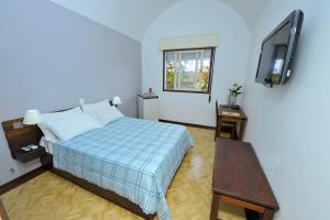 um quarto com uma cama e uma televisão de ecrã plano em Arcadas Hotel em Caçapava