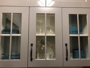 a white cabinet with plates and bowls in it at Studio Côté Sud in Superdevoluy