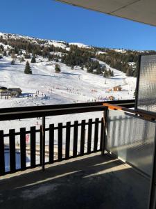 Un balcón con vista a una pista de esquí cubierta de nieve. en Studio Côté Sud, en Superdevoluy