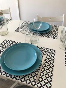 a table with two blue plates and glasses on it at Studio Côté Sud in Superdevoluy +24 photos