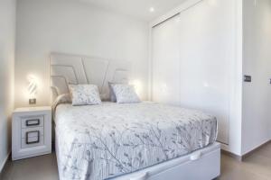 a white bedroom with a bed with a white bedspread at Intempo by Holuxe - 034 - 3rd floor in Benidorm +38 photos