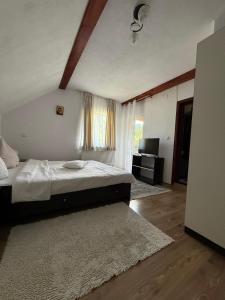 a bedroom with a large bed and a television at Pensiunea Margareta corp A, Ceahlau in Ceahlău +27 photos