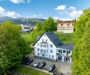 Luftaufnahme eines weißen Hauses mit davor geparkten Autos. in der Unterkunft Lawendowy Dworek in Karpacz