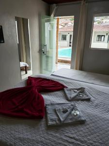 a bedroom with a bed with a red dress on it at Pousada Sinhá Moça in Diamantina