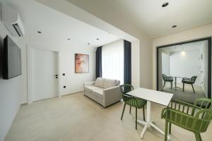 un soggiorno con un divano, un tavolo e delle sedie di Karbelsun City a Fethiye