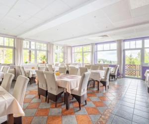 ein Esszimmer mit Tischen und Stühlen und Fenstern in der Unterkunft Lawendowy Dworek in Karpacz