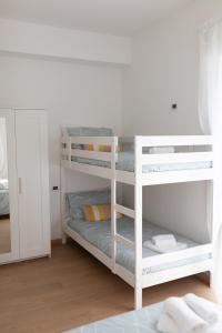 a white bunk bed with two bunk beds in a room at GM Family in Siderno Marina
