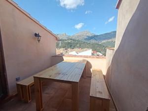 a wooden picnic table on a balcony with a view at Casa L'Olivar in Beniardá