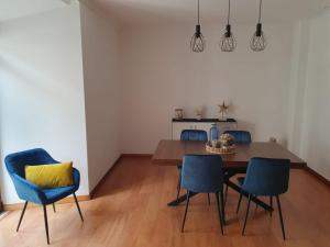 a dining room with a table and blue chairs at O AL da Baixa in Figueira da Foz