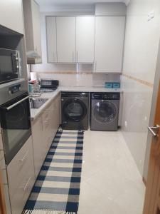 a kitchen with a washing machine and a dishwasher at O AL da Baixa in Figueira da Foz +2 photos