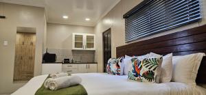 a bedroom with a large bed with a wooden headboard at Shiloah Guesthouse Unit 4 in Oranjemund +15 photos