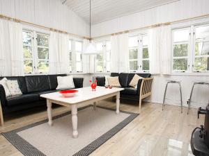 a living room with a couch and a table at 6 person holiday home in Ålbæk-By Traum in Skram