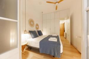 a bedroom with a bed with a blue blanket on it at Bravissimo Plaça del Vi, Authentic Historic Apartment in Girona +28 photos