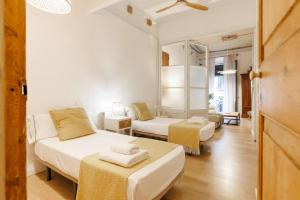 a small room with two beds and a room with at Bravissimo Plaça del Vi, Authentic Historic Apartment in Girona