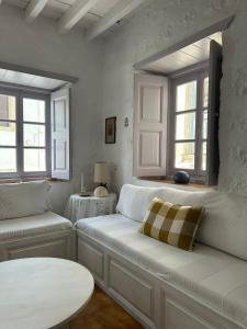 a white living room with a couch and a table at Villa Iza in Skala