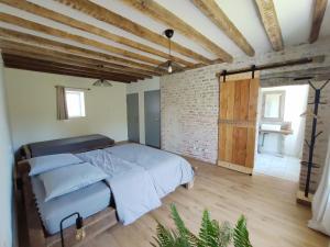 a bedroom with a bed and a brick wall at Oacisse in Coulanges