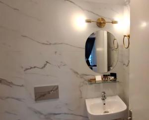a white bathroom with a sink and a mirror at ARCHONTIKO HOTEL Kalymnos in Kalymnos
