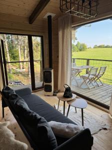 a living room with a couch and a large window at Treetop Tiny House Pod Korunami in Horná Mičiná