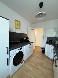 カッセルにあるSchöne Wohnung gegenüber Bahnhofの白いキッチン(洗濯機付) +3枚の写真