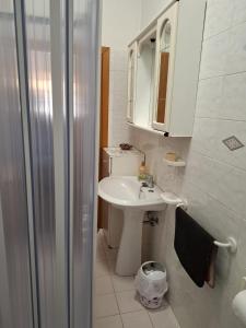 a white bathroom with a sink and a shower at Casa di Adele con giardino privato a 150 mt dal mare in Senigallia