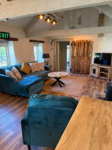 a living room with a couch and a table at Character barn in St Mellion in St Mellion