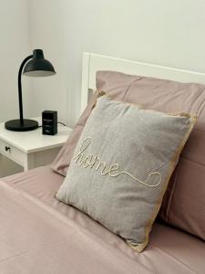 a pillow with home written on it sitting on a bed at Gemütliches Salento-Ferienhaus, zentral gelegen mit Garage, Garten und Heizung in Cutrofiano