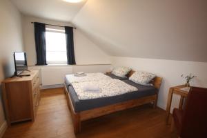 a small bedroom with a bed and a window at Pension Luci in Boffzen