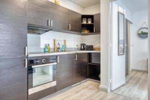 a kitchen with stainless steel appliances and wood cabinets at Frau - 2 suites avec ascenseur à côte de la Cathédrale de Rouen ! in Rouen