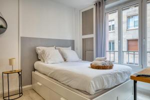 a bedroom with a bed with a basket on it at Frau - 2 suites avec ascenseur à côte de la Cathédrale de Rouen ! in Rouen