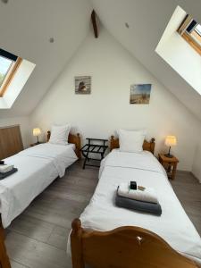 two beds in a room with white walls and windows at La grange des rosiers in Cambron +33 photos