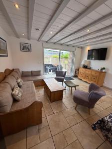 a living room with a couch and a table at La grange des rosiers in Cambron